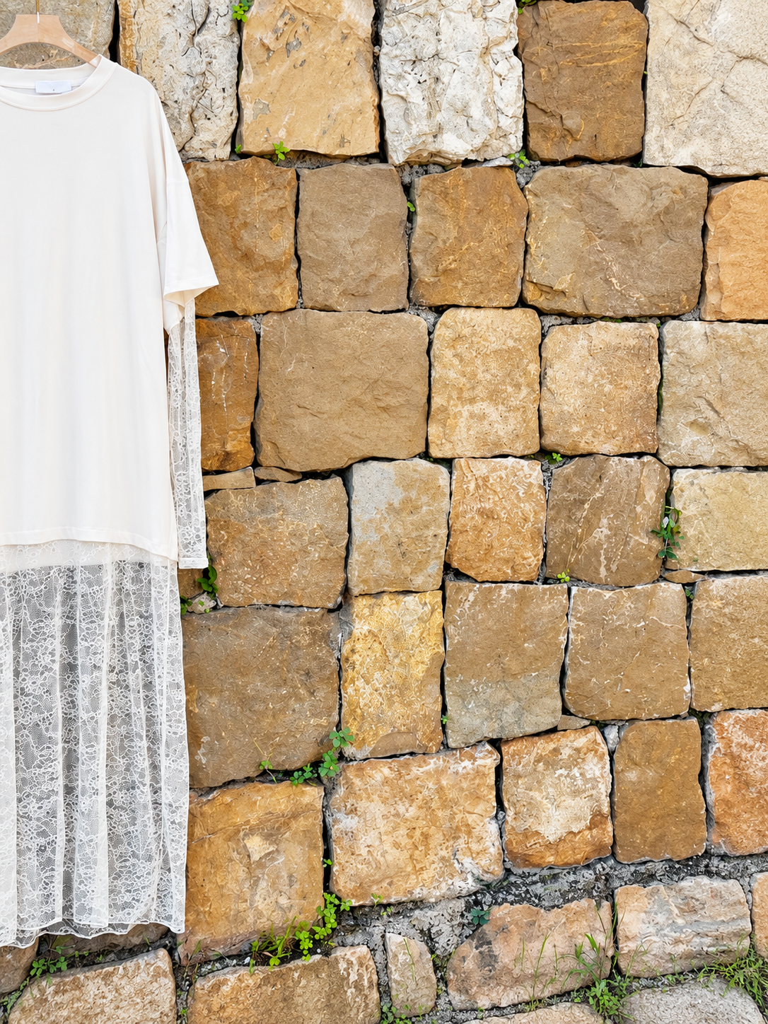 Vestido de Encaje ante Muro de Piedra